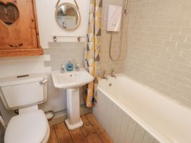 A bathroom with a sink, toilet and bathtub at Rock Cottage in Milnthorpe
