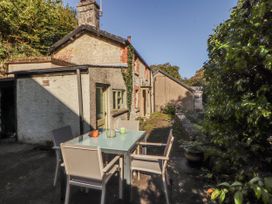 A house with a table and chairs on the patio at Rock Cottage in Milnthorpe