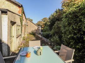 An outdoor seating area with a table and mugs at Rock Cottage in Milnthorpe