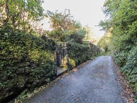 A pathway with stone walls and a gate at Rock Cottage in Milnthorpe