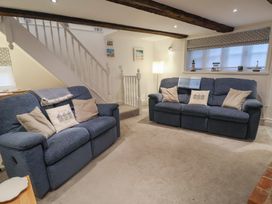 A living room with sofas and a lamp at Nutshell in Aldeburgh