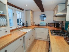 A kitchen with a sink and stove at Nutshell in Aldeburgh