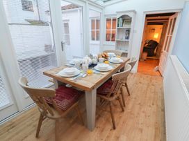 A dining table set with dishes in a sunroom at Nutshell in Aldeburgh