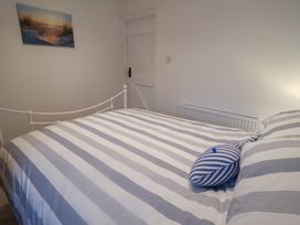 A bedroom with a bed and blue striped pillow at Nutshell in Aldeburgh