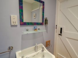 A bathroom with a sink and mirror at Nutshell in Aldeburgh