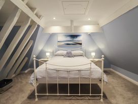 A bedroom with a bed and nightstands at Nutshell in Aldeburgh