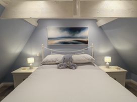 A bedroom with a bed and nightstands at Nutshell in Aldeburgh
