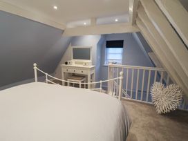 A bedroom with a bed and vanity at Nutshell in Aldeburgh
