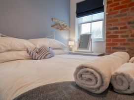 A bedroom with bed and towels at The Nutshell in Aldeburgh