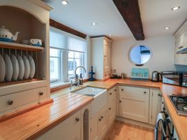 A kitchen with a sink and cooking area at The Nutshell in Aldeburgh
