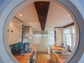 A kitchen with a stove and sink at The Nutshell in Aldeburgh