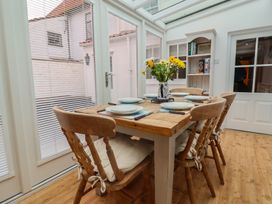 A conservatory with a table and chairs at The Nutshell in Aldeburgh