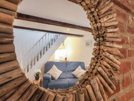 A living room with a mirror and couch at The Nutshell in Aldeburgh