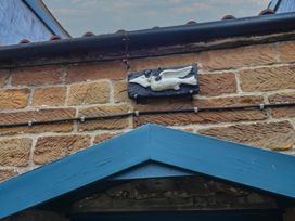 An ornamental plaque on a stone wall at Dove Cottage in Sneaton near Ruswarp