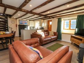 A living room with a sofa and dining area at Dove Cottage in Sneaton near Ruswarp