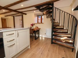 A kitchen with a spiral staircase and dining area at Dove Cottage in Sneaton near Ruswarp