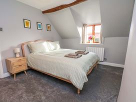 A bedroom with a bed and nightstand at Dove Cottage in Sneaton near Ruswarp