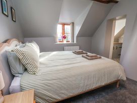 A bedroom with a bed, towels, and a window at Dove Cottage in Sneaton near Ruswarp