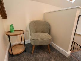 A chair and side table with a pitcher at Dove Cottage Sneaton near Ruswarp