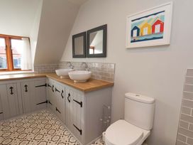 A bathroom with two sinks and a toilet at Dove Cottage in Sneaton near Ruswarp