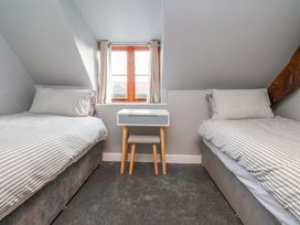 A bedroom with two beds and a table at Dove Cottage Sneaton near Ruswarp