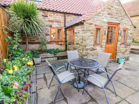 An outdoor seating area with a table and chairs at Dove Cottage in Sneaton near Ruswarp