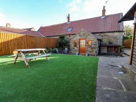 A garden with a table and chairs at Dove Cottage in Sneaton near Ruswarp