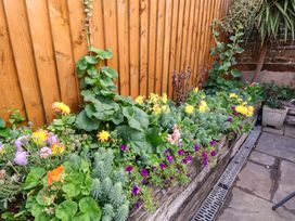 A garden with flowers in a planter at Dove Cottage in Sneaton near Ruswarp