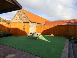 A garden with a picnic table and fence at Dove Cottage Sneaton near Ruswarp