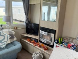 A living room with a television and fireplace at Ty Cariad