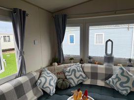 A living room with a sofa and cushions at Ty Cariad