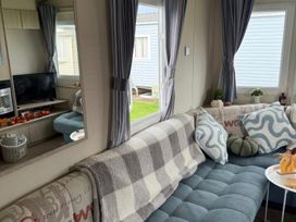 A living room with a sofa and television at Ty Cariad