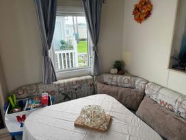 A dining area with a table and sofa at Ty Cariad