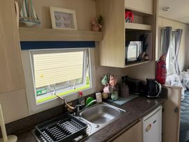 A kitchen with a sink and appliances at Ty Cariad