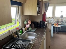 A kitchen with a sink and kettle at Ty Cariad