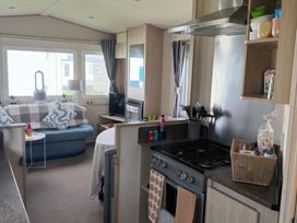 A living room with a sofa and stove at Ty Cariad