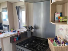 A kitchen with a stove and utensils at Ty Cariad