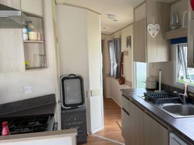A kitchen with a sink and gas stove at Ty Cariad