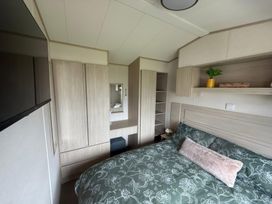 A bedroom with a bed, wardrobe and mirror at Ty Cariad