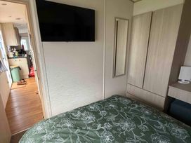 A bedroom with a bed and television at Ty Cariad in 