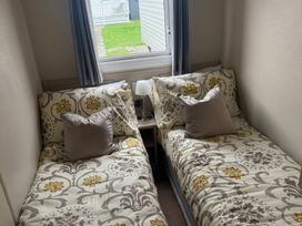 A bedroom with two single beds and a window at Ty Cariad