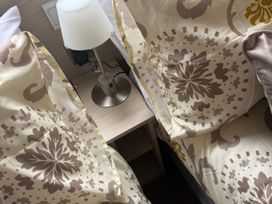 A bedroom with pillows and a lamp on a table at Ty Cariad