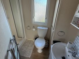 A bathroom with a toilet, sink, and shower at Ty Cariad