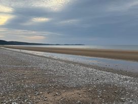 A beach with sand and pebbles at Ty Cariad