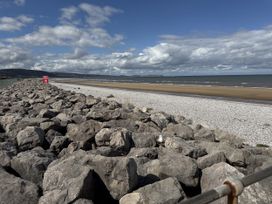 A beach with rocks and ocean at Ty Cariad in Towyn