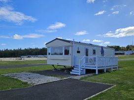 A caravan with a deck and steps at Thurston Manor Caravan Park, Pony Meadow, Dunbar