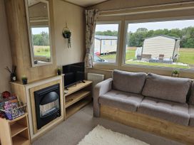 A living room with a sofa and television at Thurston Manor Caravan Park, Pony Meadow, Dunbar