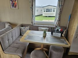 A dining area with seating and a welcome sign at Thurston Manor Caravan Park, Pony Meadow, Dunbar
