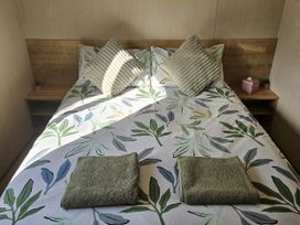 A bed with pillows and towels at Thurston Manor Caravan Park, Pony Meadow, Dunbar