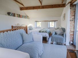A bedroom with a sofa and two beds at The Little Barn Fluxton Nr. Ottery St Mary